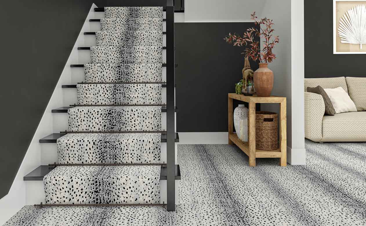 Entry way with animal printed carpet and matching stair runner