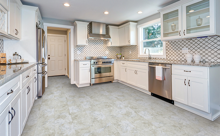 luxury vinyl flooring with white patterned backsplash in kitchen